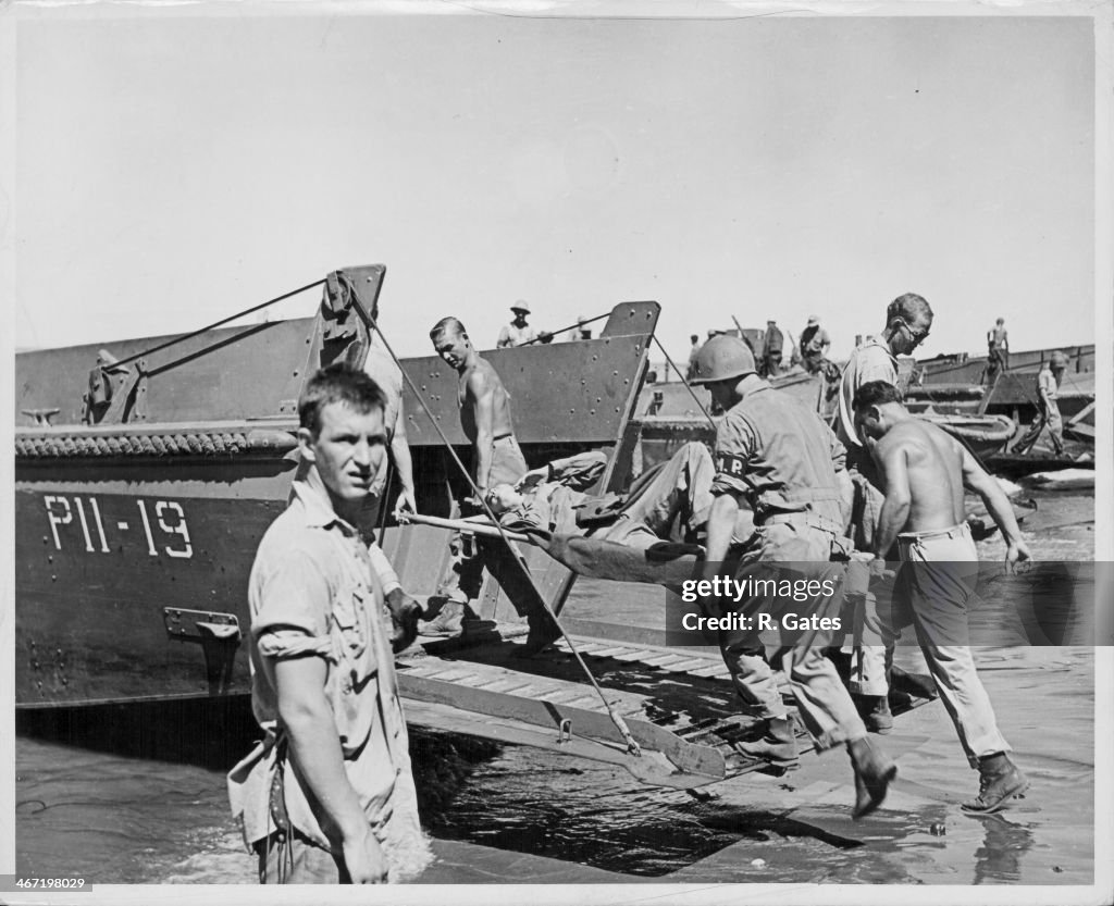 Ww2 Loading Net US Marines loading equipment onto landing craft vehicles as they ...