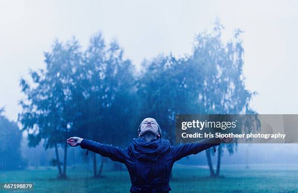 young woman standing in fog and rain - hoofd achteroven stockfoto's en -beelden