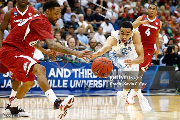 Marcus Paige of the North Carolina Tar Heels dribbles by Rashad Madden of the Arkansas Razorbacks in the second half during the third round of the...