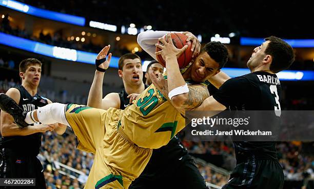 Zach Auguste of the Notre Dame Fighting Irish and Alex Barlow of the Butler Bulldogs go after the ball in the second half during the third round of...