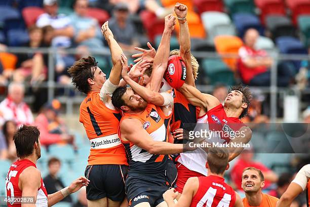 Phil Davis and Shane Mumford of the Giants and Sam Naismith of the Swans contest a mark during the NAB Challenge AFL match between the Greater...