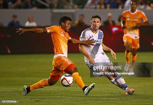 Robbie Keane of Los Angeles Galaxy plays the ball past Luis Garrido of Houston Dynamo in the first half during the MLS match at StubHub Center on...