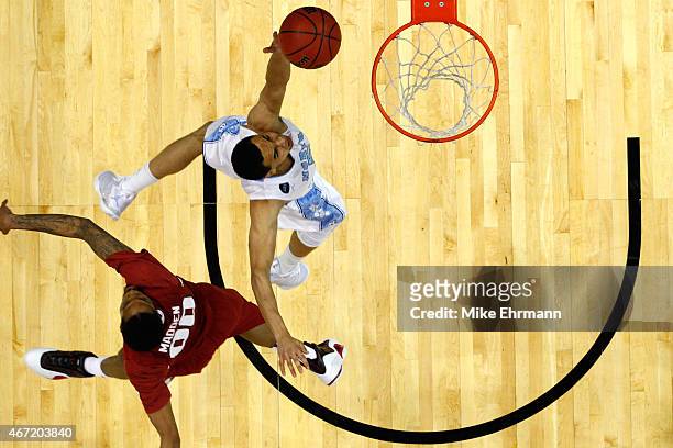Marcus Paige of the North Carolina Tar Heels dunkes over Rashad Madden of the Arkansas Razorbacks during the third round of the 2015 NCAA Men's...