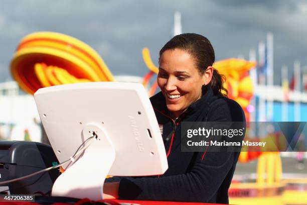 Olympic bobsledder Lolo Jones stops by McDonald's Cheers To Sochi display in the Athletes Village to read good luck messages from fans ahead of the...