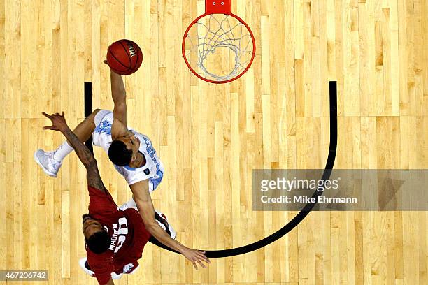 Marcus Paige of the North Carolina Tar Heels puts up a shot as he is defended by Rashad Madden of the Arkansas Razorbacks during the third round of...