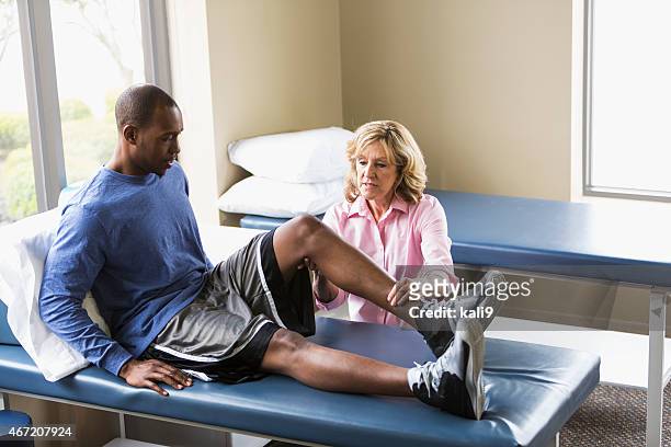 physical therapist examining patient - professional sportsperson stock pictures, royalty-free photos & images
