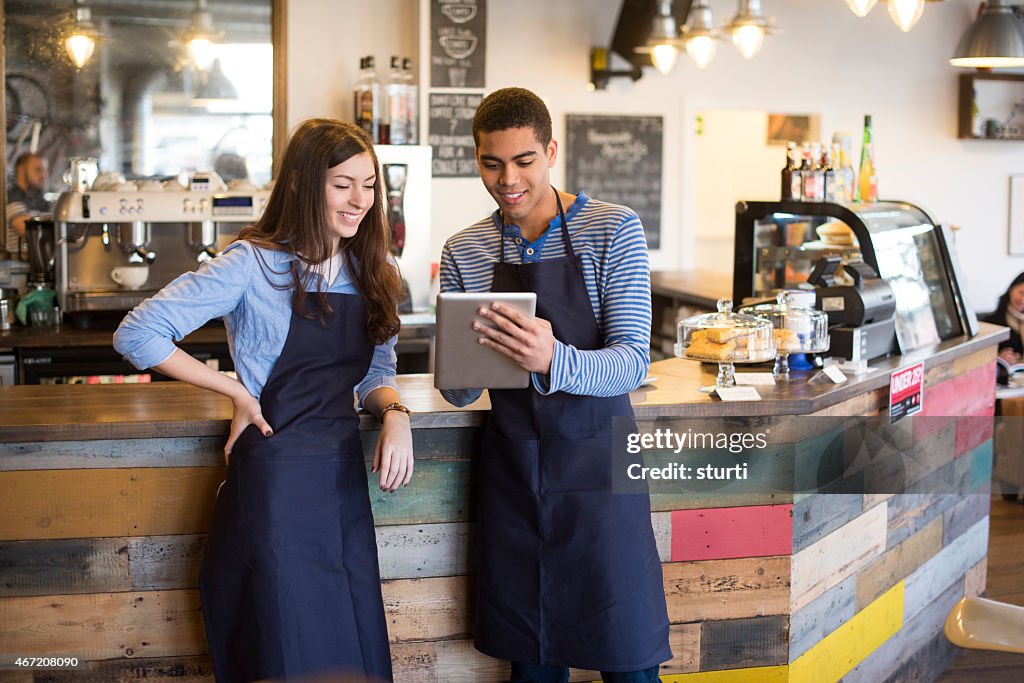 Coffee shop workers using a digital tablet