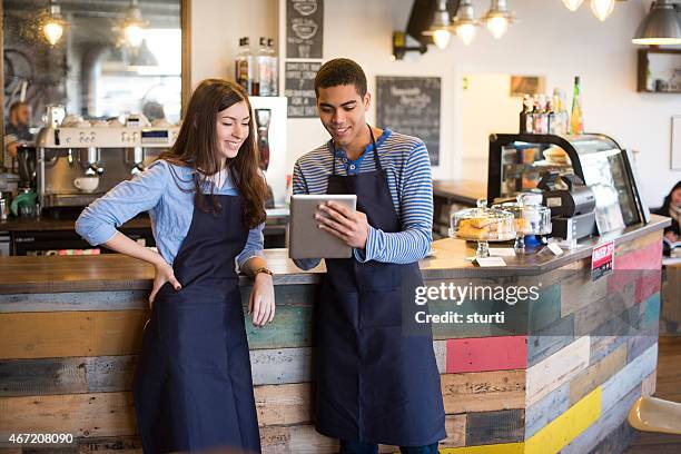 coffee shop workers using a digital tablet - part time worker stock pictures, royalty-free photos & images