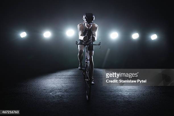 cyclist riding at night in the city - stadium lights stock pictures, royalty-free photos & images