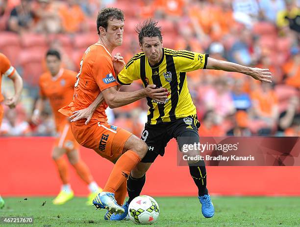 Nathan Burns of Wellington Phoenix and Luke DeVere of the Roar challenge for the ball during the round 22 A-League match between the Brisbane Roar...