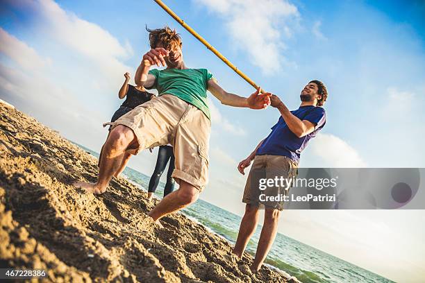 limbo-spiel am strand - limbo stock-fotos und bilder