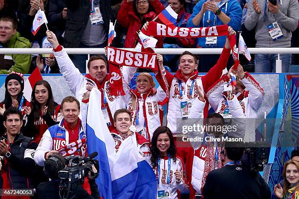 Members of the Russian team celebrate as Evgeny Plyushchenko of Russia competes in the Figure Skating Men's Short Program during the Sochi 2014...