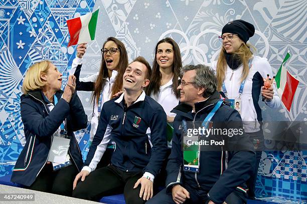 Paul Bonifacio Parkinson of Italy waits with teammates for his scores in the Figure Skating Men's Short Program during the Sochi 2014 Winter Olympics...