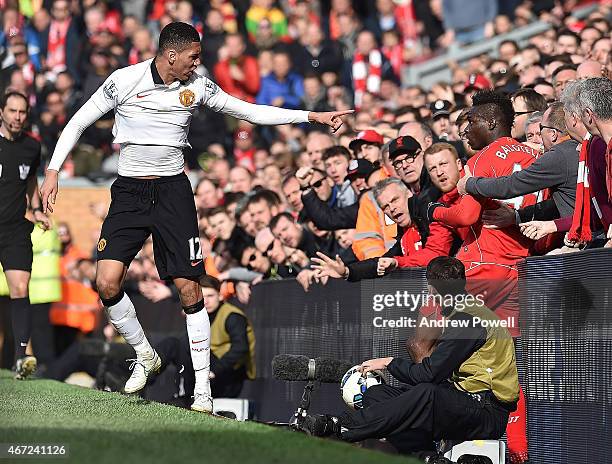 Mario Balotelli of Liverpool and Chris Smalling of Manchester United end up in with the fans during the Barclays Premier League match between...
