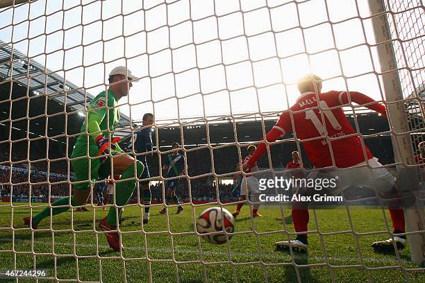Luiz Gustavo of Wolfsburg scores his team's first goal against goalkeeper Lorius Karius and Yunus Malli of Mainz during the Bundesliga match between...