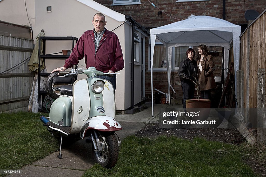 Male skinhead with scooter and family