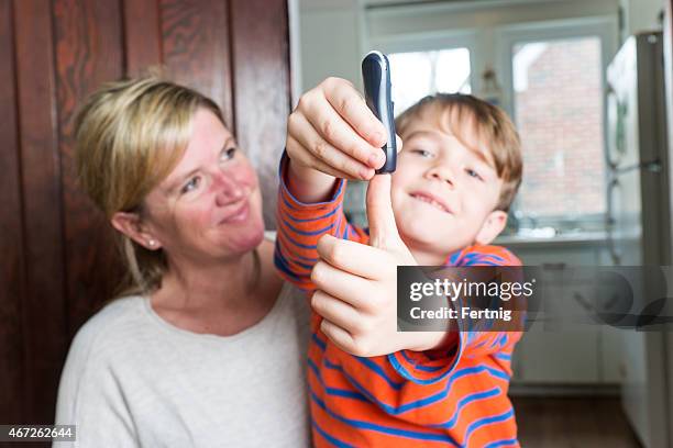 little boy with diabetes on his mother's lap. - type 1 diabetes stock pictures, royalty-free photos & images