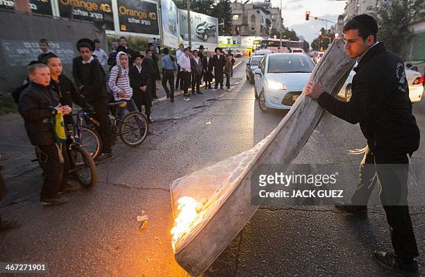 Young ultra-Orthodox Jews burn a mattress in order to block a street during a protest against ultra-Orthodox young men being called up for military...