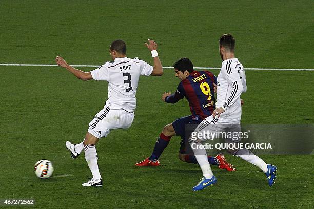 Barcelona's Uruguayan forward Luis Suarez scores a goal past Real Madrid's Portuguese defender Pepe and Real Madrid's defender Sergio Ramos during...