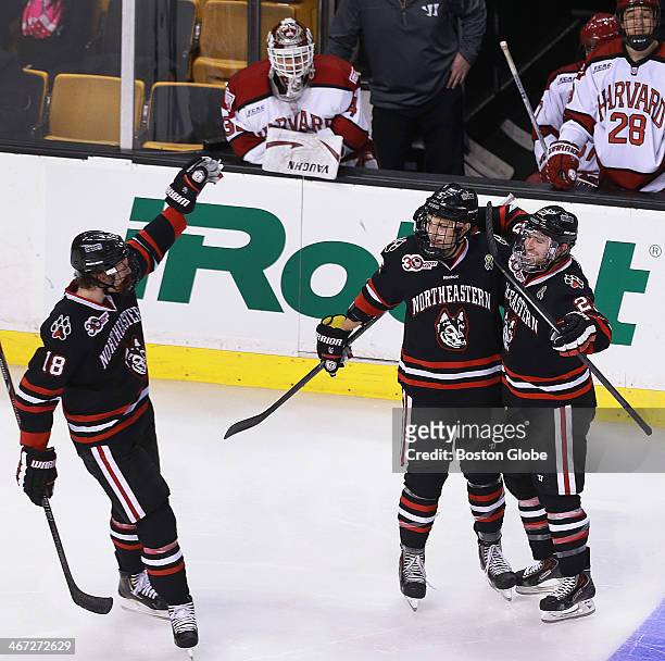 After giving up four goals in the first two periods, Harvard's starting goalie Raphael Girard, on bench at upper left, was pulled between periods,...