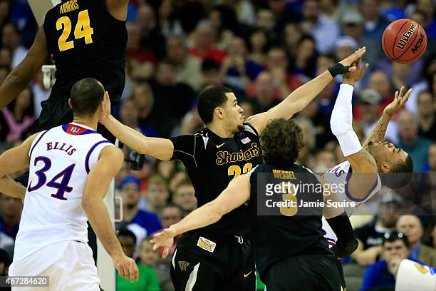 Frank Mason III of the Kansas Jayhawks has a shot blocked by Fred VanVleet of the Wichita State Shockers in the second half during the third round of...