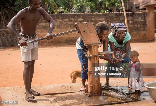african family at a well - west africa stock pictures, royalty-free photos & images