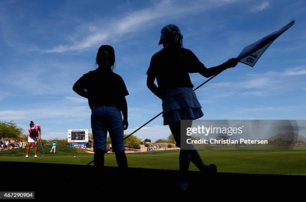 Seon Hwa Lee of South Korea putts on the 18th green as 'Girls Golf' members tend the pin during the final round of the LPGA Founders Cup at Wildfire...