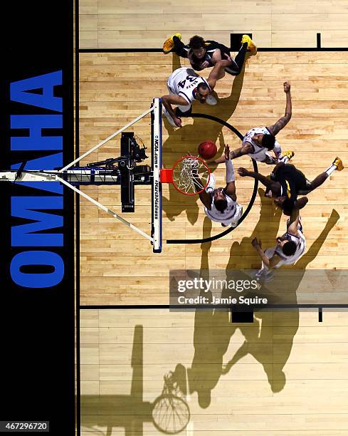 Kelly Oubre Jr. #12 and Landen Lucas of the Kansas Jayhawks jump for a rebound during the third round game of the NCAA Basketball Tournament against...