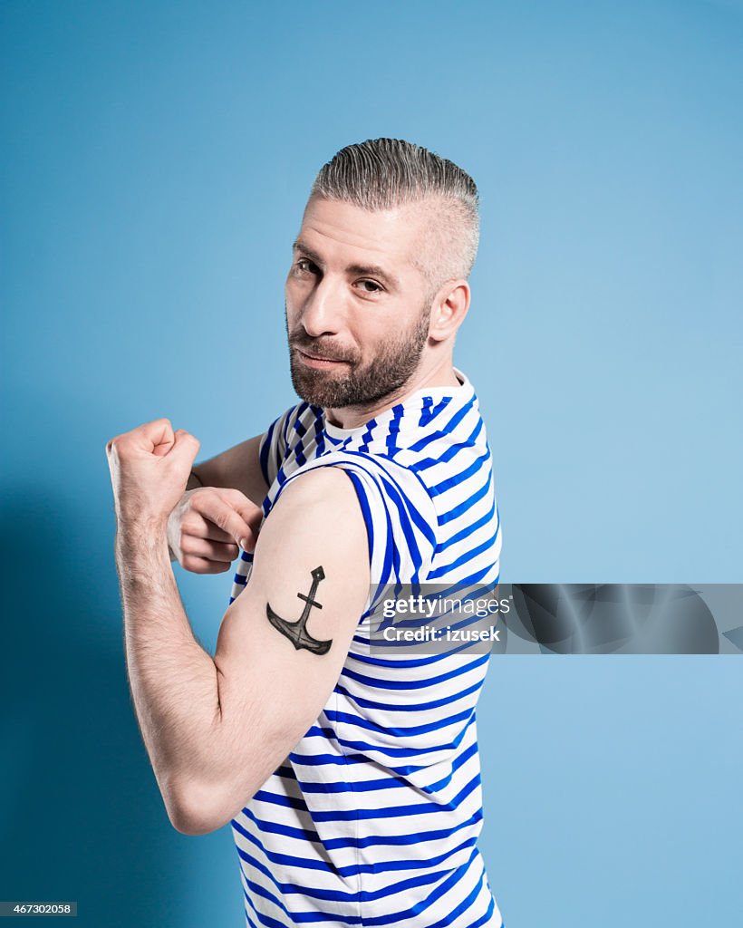 Bearded sailor man showing his anchor tatoo