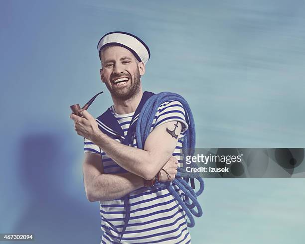 happy bearded sailor man holding pipe and rope - sailor hat 個照片及圖片檔