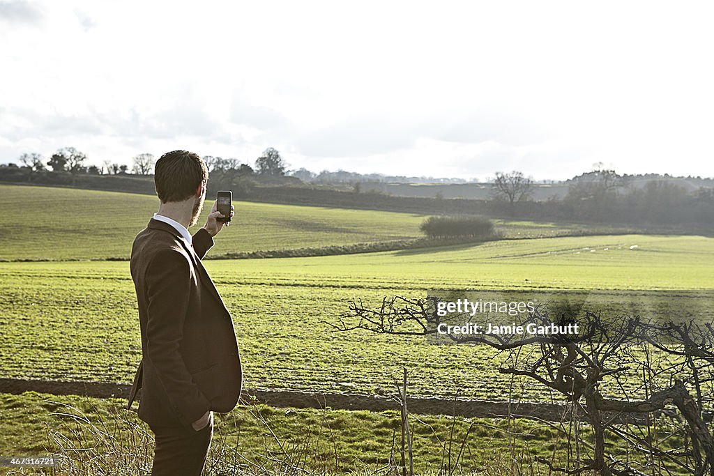 Gentleman in a tweed suit taking a photograph