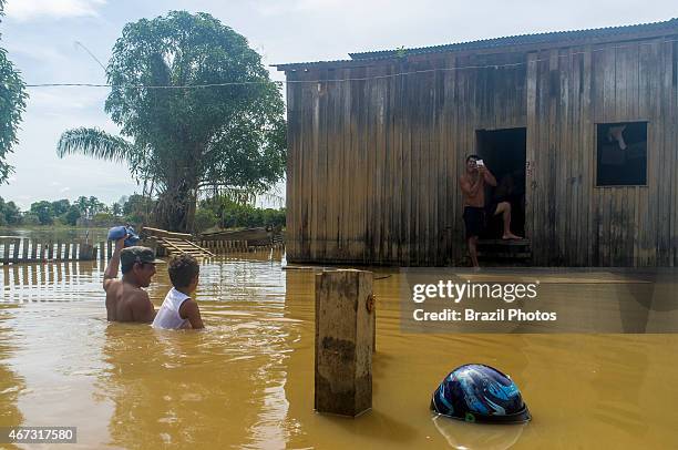 Flooding in Brazilian Amazon - flooded house in Taquari district, Rio Branco city, Acre State - man shaves at front door while another man helps boy...