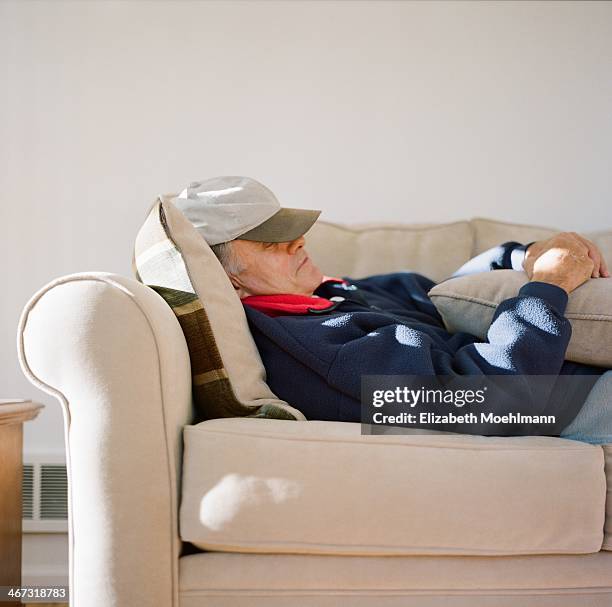 man sleeping on couch - man sleeping with cap stock pictures, royalty-free photos & images