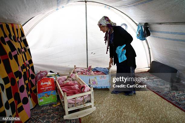 Khanon Hamo from Kobani tends to her 7-month-old twins in her tent in a refugee camp on March 22, 2015 in Suruc, in the province of Sanliurfa,...