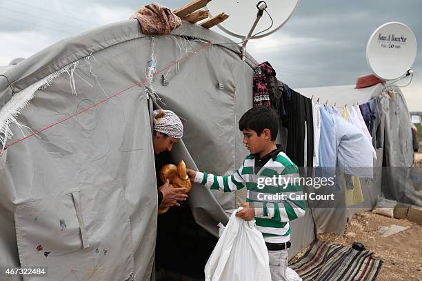 Boy distributes food in a refugee camp on March 22, 2015 in Suruc, in the province of Sanliurfa, Turkey. Turkey has one of the largest populations of...