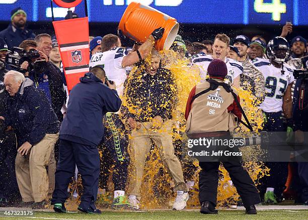 Tight end Zach Miller of the Seattle Seahawks dumps Gatorade on head coach Pete Carroll in the fourth quarter of Super Bowl XLVIII against the Denver...