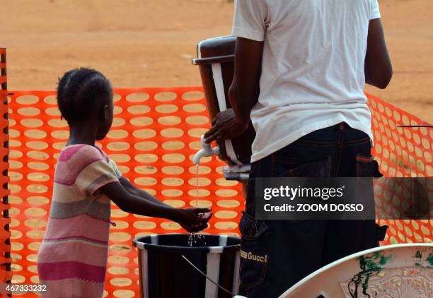 Child washes her hands at a vaccination center against measles in a poor neighborhood of Monrovia on March 19, 2015. The people of Monrovia's Peace...