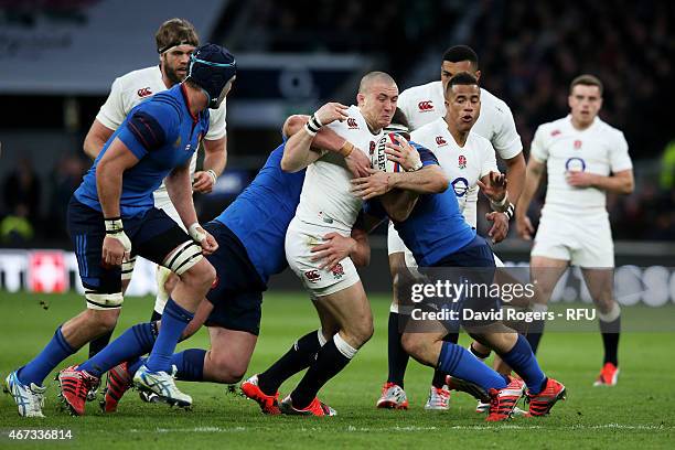 Mike Brown of England is wrapped up by the France defence during the RBS Six Nations match between England and France at Twickenham Stadium on March...