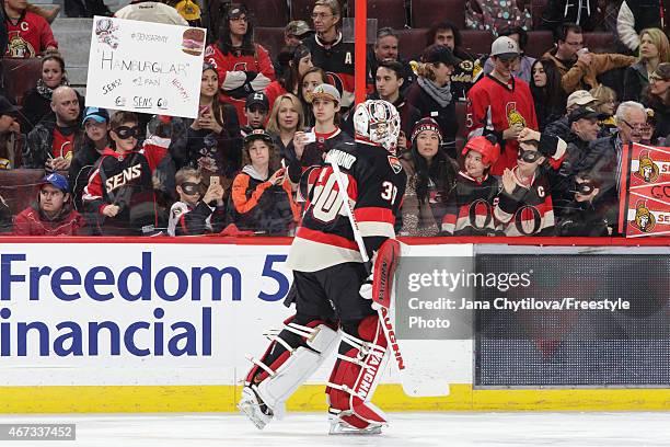 Andrew Hammond of the Ottawa Senators skates past fans wearing Hamburglar masks during warmups prior to an NHL game against the Boston Bruins at...