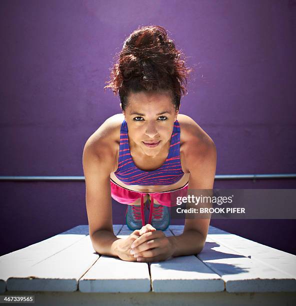 young woman doing plank core pose - woman running shorts stock pictures, royalty-free photos & images