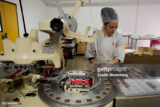 An employee sends chocolates through a machine to be wrapped in foil at the Jacques Torres Chocolate factory in the Brooklyn borough of New York,...