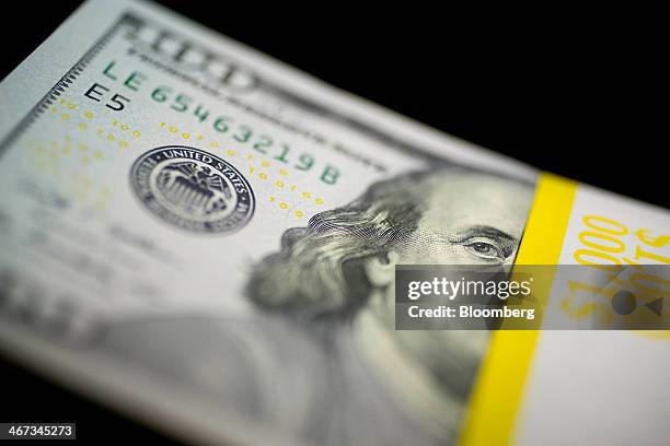 Bill sits on a stack of currency in this arranged photograph in Washington, D.C., U.S., on Thursday, Feb. 6, 2014. A suspension of the federal debt...