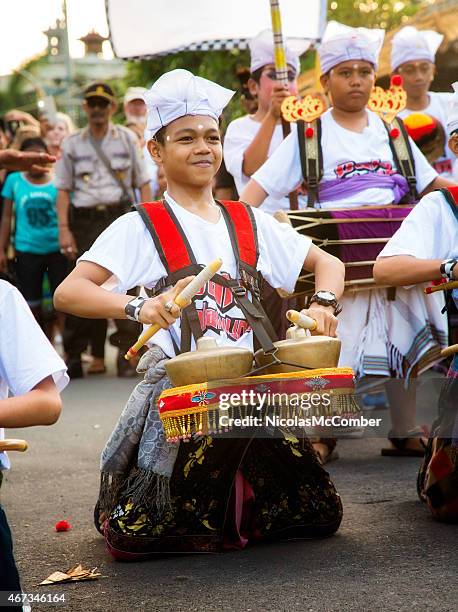 pre-teen indonesian boy playing bonang metallophones during  ngrupuk parade - gamelan stock pictures, royalty-free photos & images