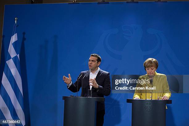 Greek Prime Minister Alexis Tsipras gestures while he and German Chancellor Angela Merkel speak to the media following talks at the Chancellery on...