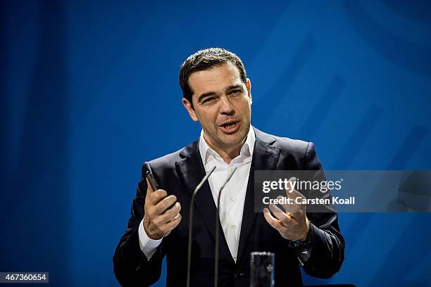 Greek Prime Minister Alexis Tsipras gestures while he and German Chancellor Angela Merkel speak to the media following talks at the Chancellery on...