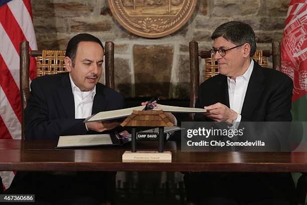 Afghanistan Finance Minister Eklil Hakimi and U.S. Treasury Secretary Jacob Lew exchange copies of a memorandum of understanding during talks at Camp...