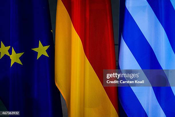 The flags of the European Union, Greece and Germany stays beside as German Chancellor Angela Merkel and Greek Prime Minister Alexis Tsipras speak to...