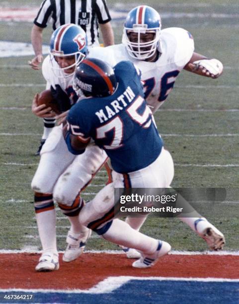 Quarterback John Elway of the Denver Broncos is sacked by George Martin of the New York Giants scoring a safety during Super Bowl XXI on January 25,...