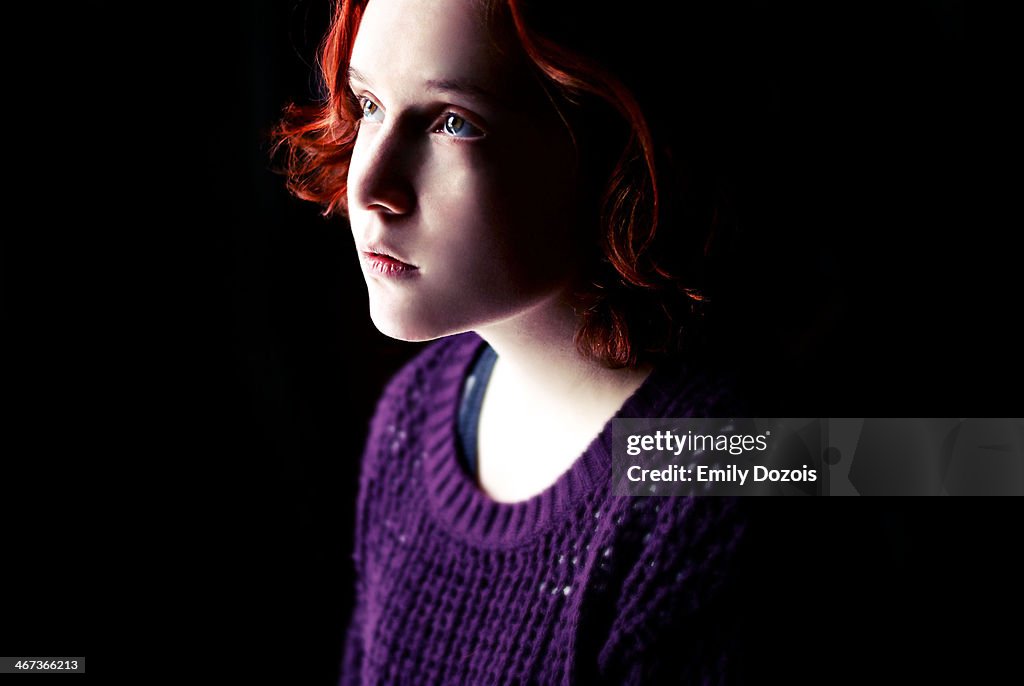 Girl facing a light on a dark background