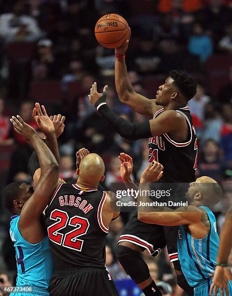 Jimmy Butler of the Chicago Bulls goes up a shot over teammate Taj Gibson and Michael Kidd-Gilchrist and Gerald Henderson of the Charlotte Hornets at...